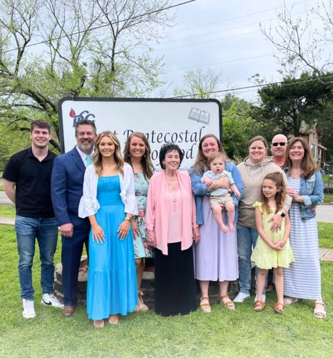 Pastor Joyce’s family on the lawn in front of the church sign