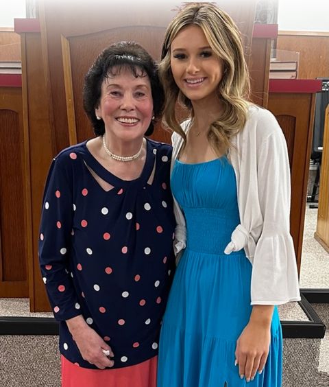 Pastor Joyce with her granddaughter, who wears a blue dress
